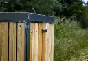 Udendørs skraldespand med låg i lærk.webp